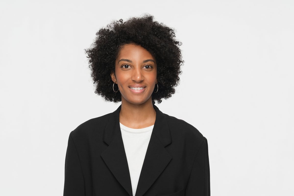 Confident woman wearing professional attire, smiling warmly